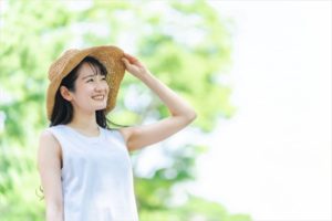 紫外線を麦わら帽子でよける女性