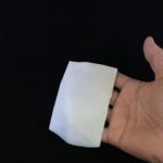 バイオセルロースの折り畳んだシートマスクを手に持つ様子