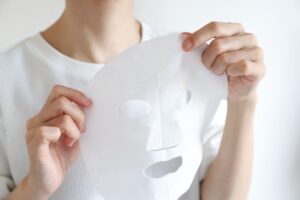 フェイスマスクを広げて持っている女性