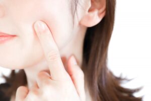 頬に指を当てる女性の口元