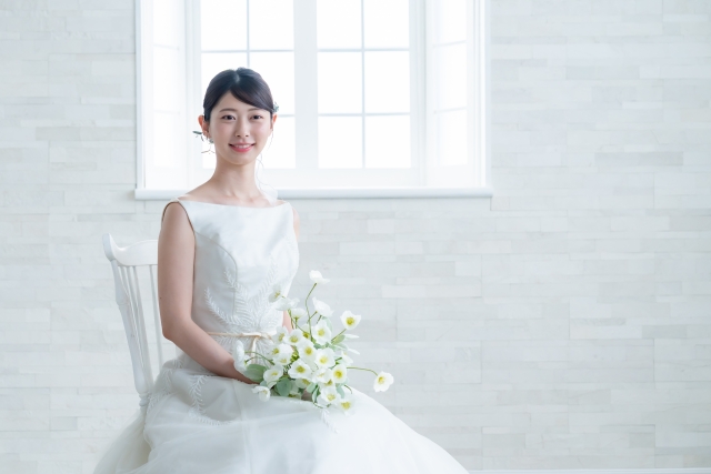 ウェディングドレスを着て椅子に座る女性