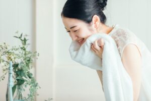 タオルで顔を優しく拭く女性